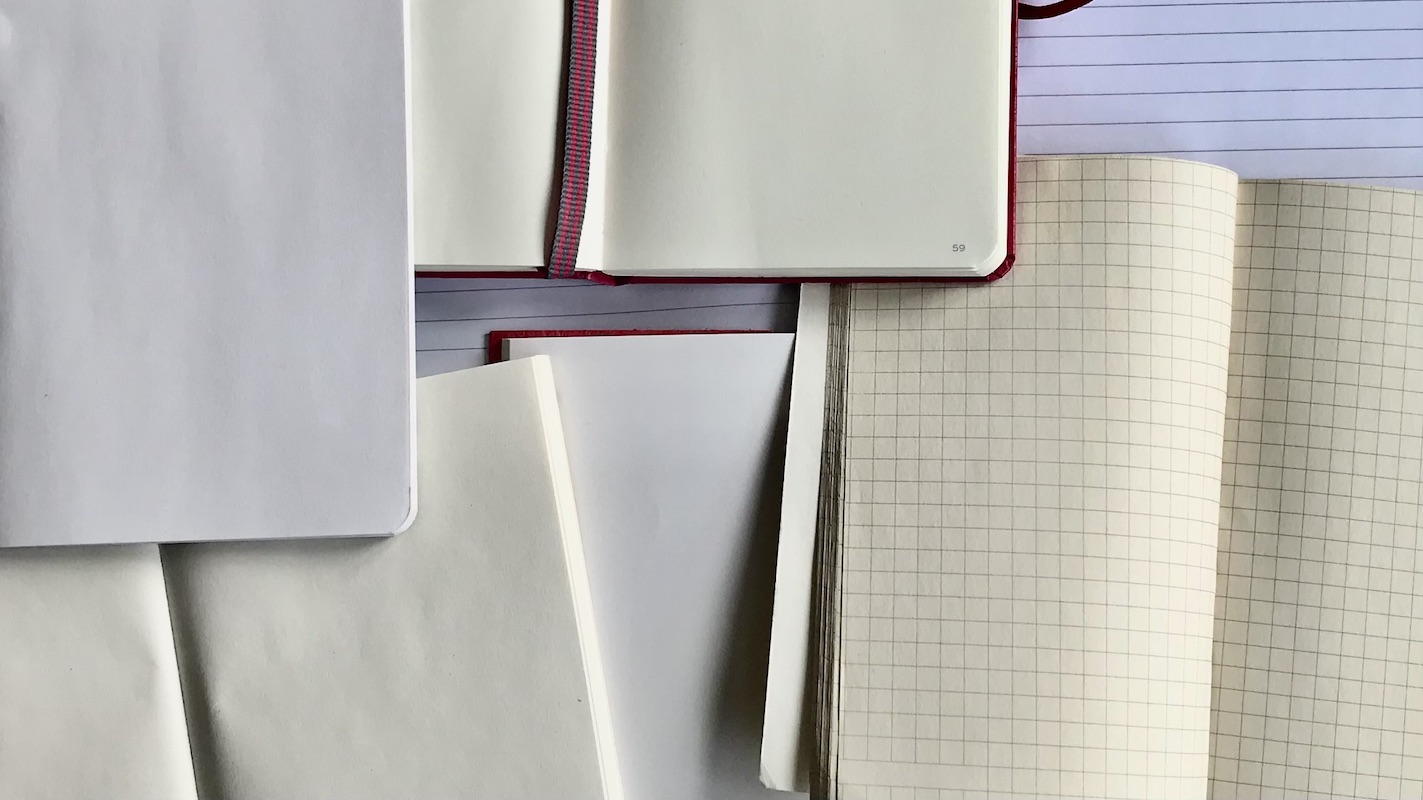 Mehrere aufgeschlagene unbeschriebene Notizbücher