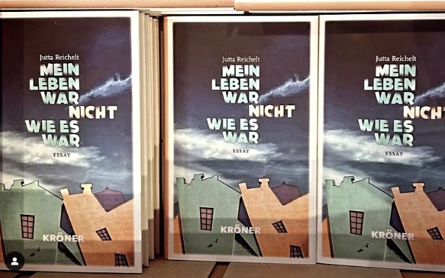 Ein geöffneter Karton, in dem drei nebeneinander drei Stapel des Buches "Mein Leben war nicht, wie es war. Essay" zu sehen sind.